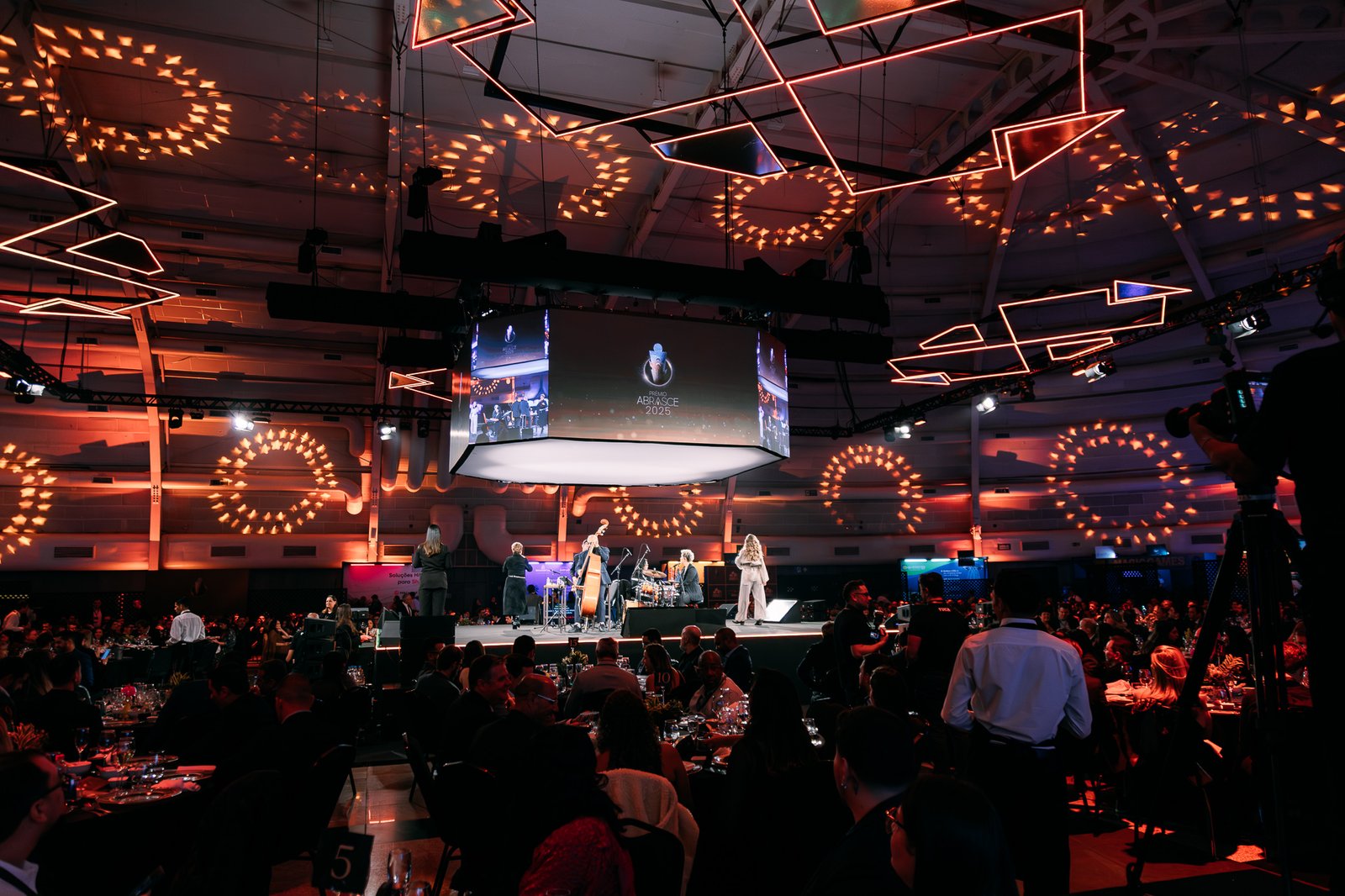 Profissionais de eventos em um ambiente moderno com tecnologia e ações sustentáveis em destaque.