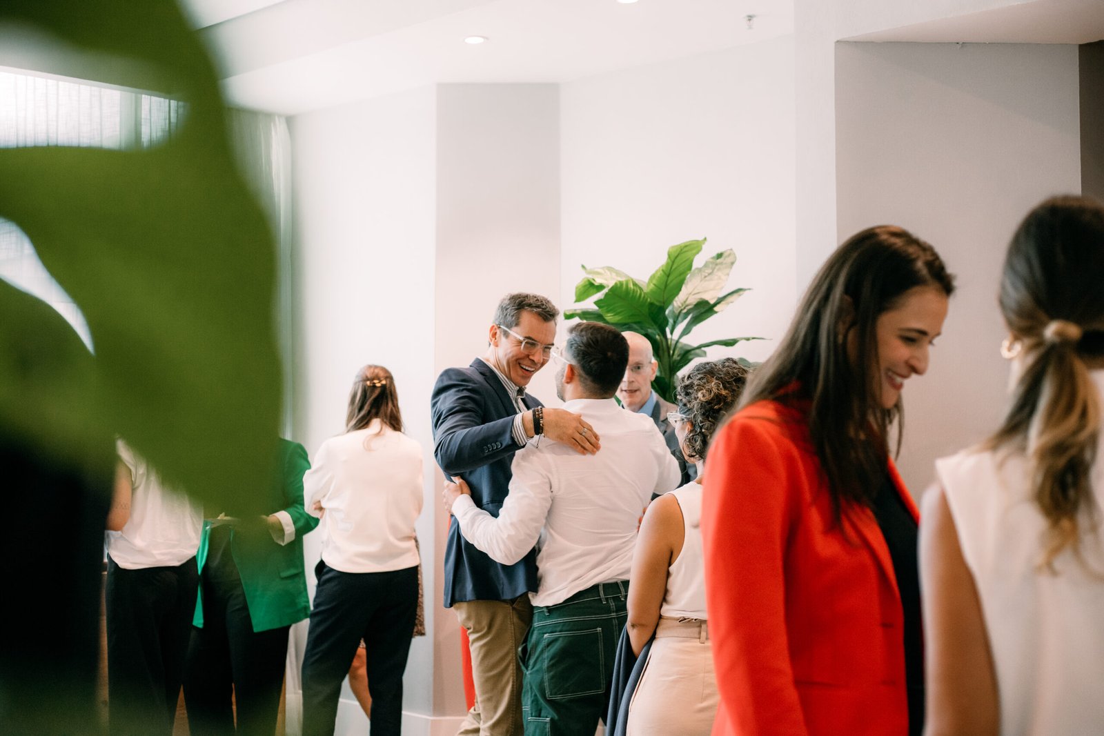 Executivos reunidos em um evento presencial no WTC Events Center, interagindo em ambiente moderno e colaborativo.