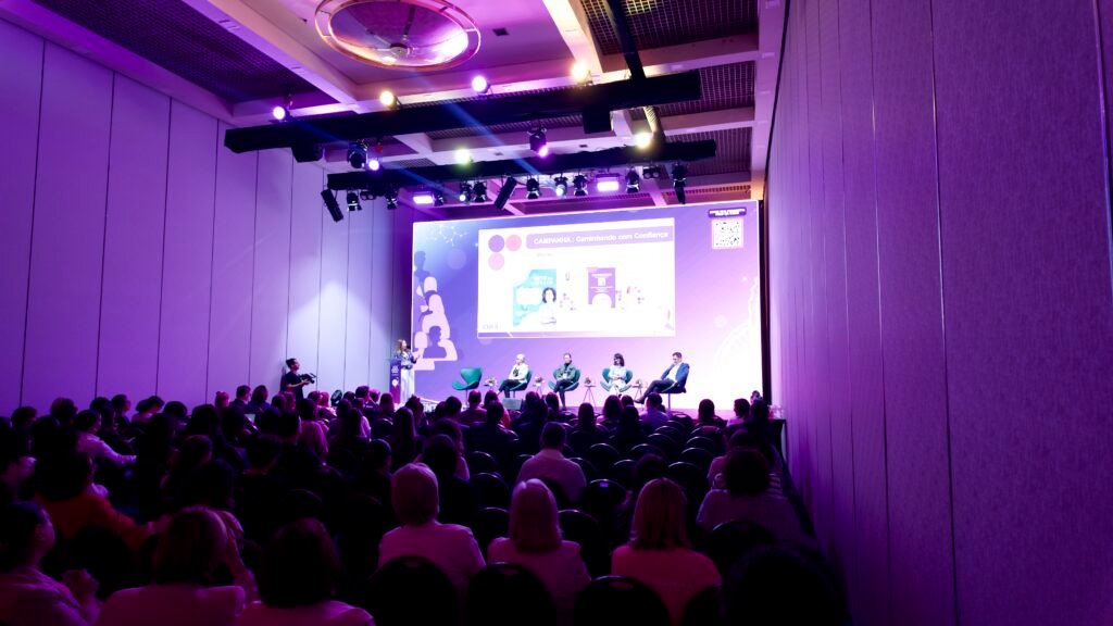 Auditório moderno do WTC Events Center durante um kick-off corporativo, com participantes atentos e estrutura de alto padrão.