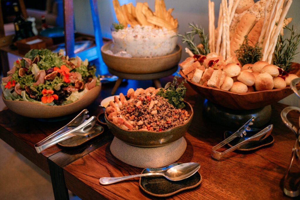 Mesa elegante de coffee break com finger foods, bebidas e elementos decorativos, pronta para um evento corporativo.