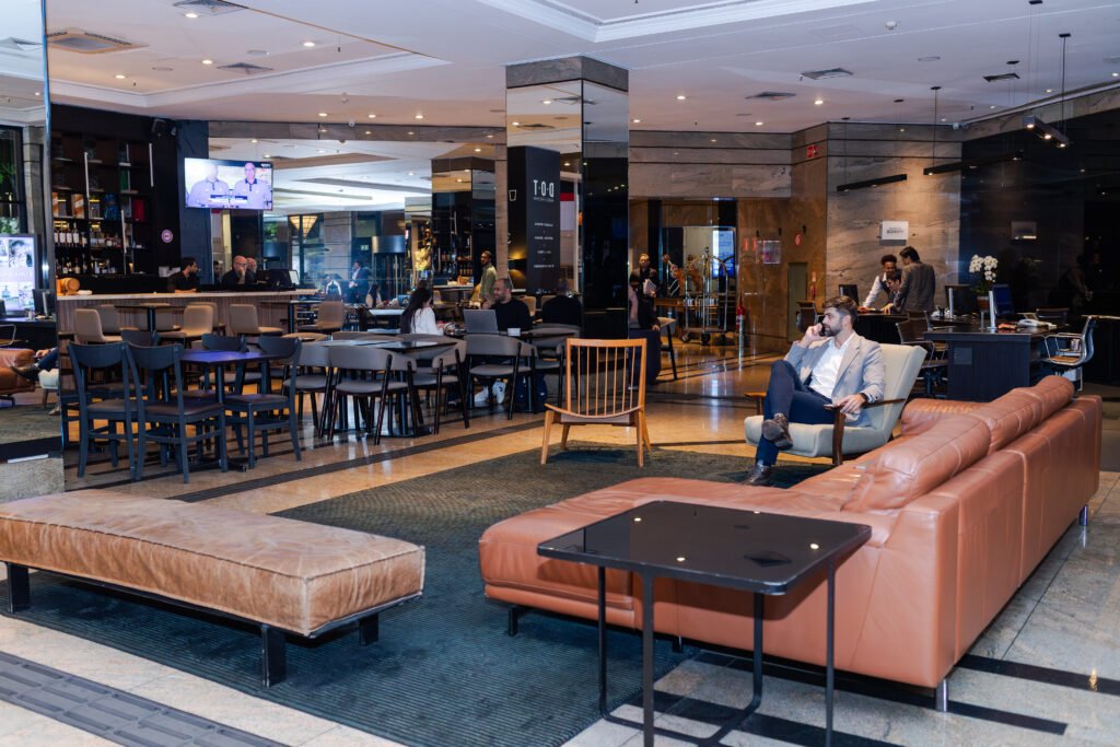 Lobby do Sheraton São Paulo WTC com executivos em check-in durante período pós-Carnaval corporativo.