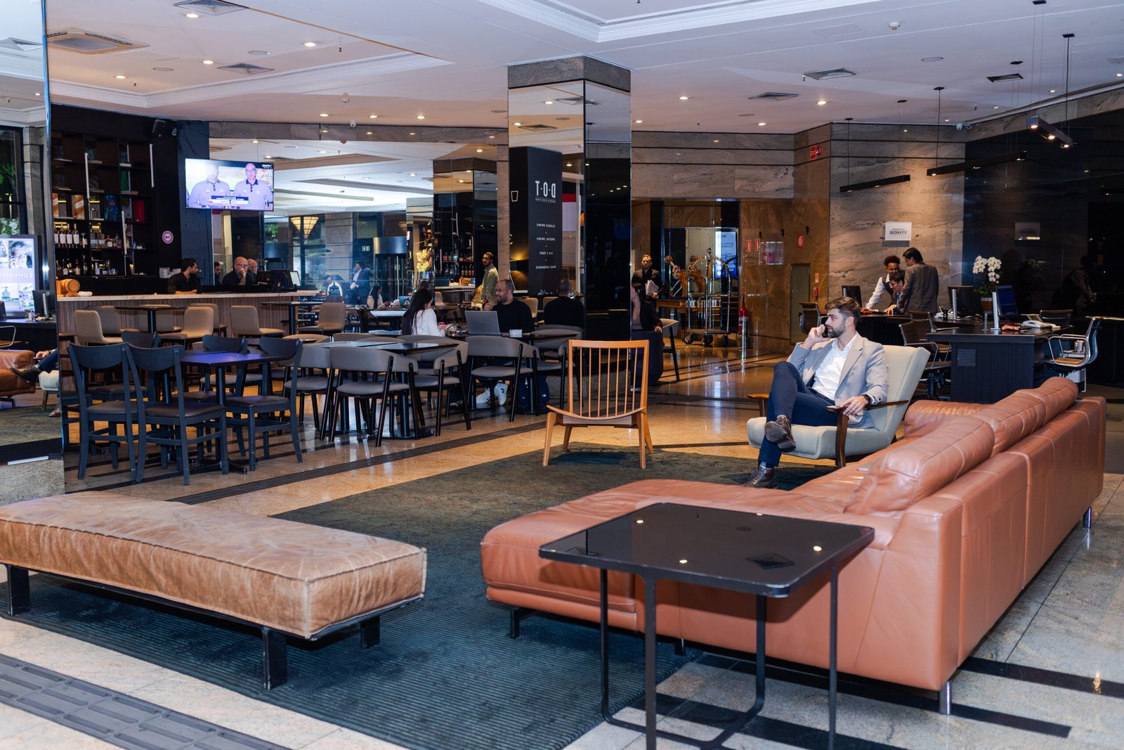 Lobby do Sheraton São Paulo WTC com executivos em check-in durante período pós-Carnaval corporativo.