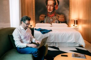 Executivo trabalhando em quarto do Sheraton São Paulo WTC Hotel com estação de trabalho e vista da região da Berrini.